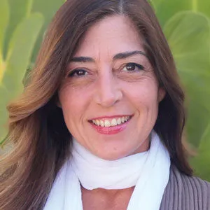 Smiling woman with long brown hair wearing a white scarf