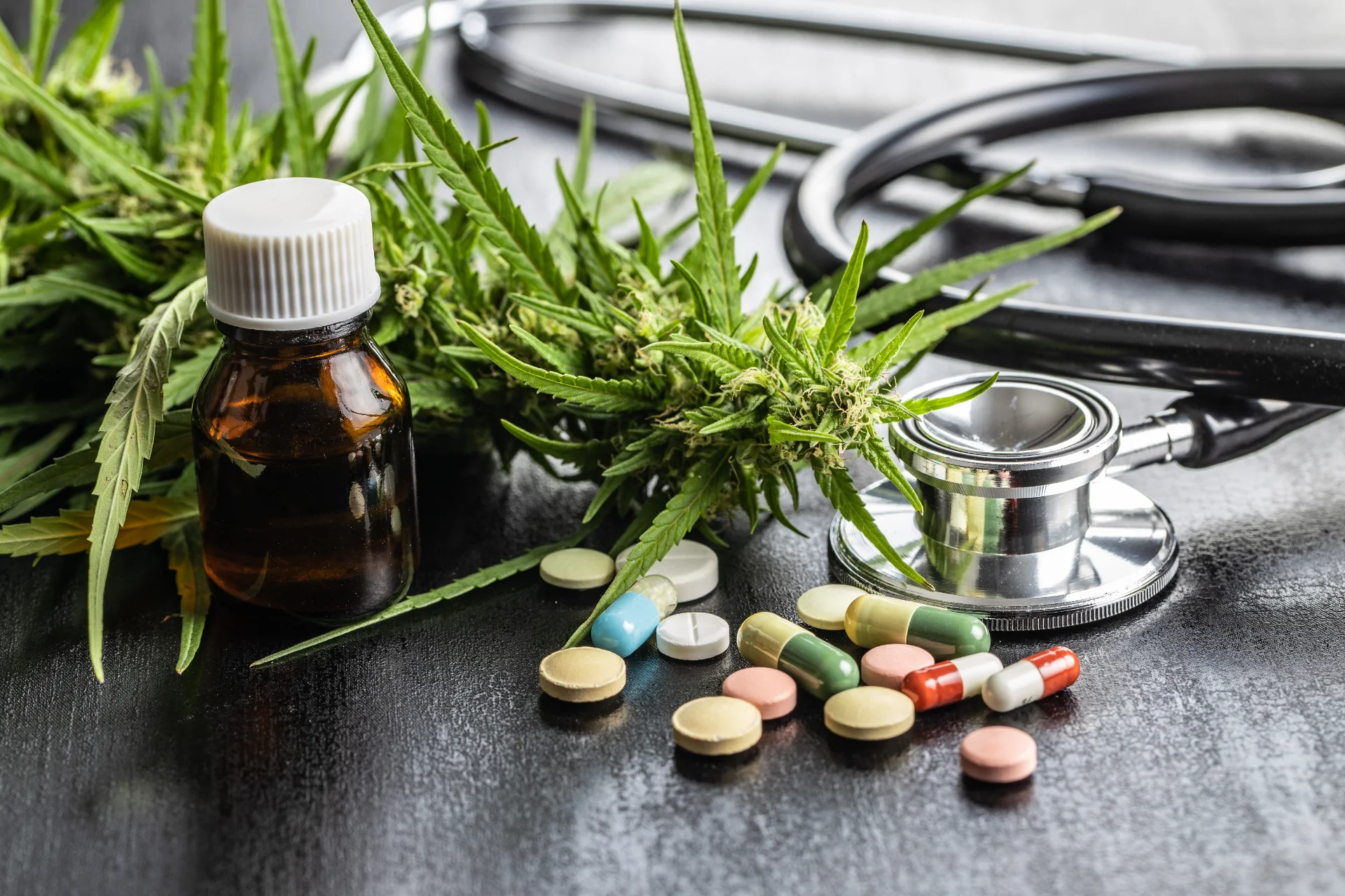 Medical marijuana cannabis flower on table with stethoscope and other medicinal pills